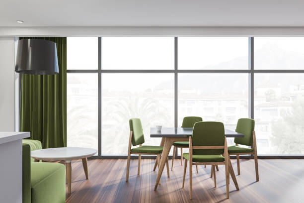 istock Bright dining room interior with green sofa, chair, panoramic window 1362722241