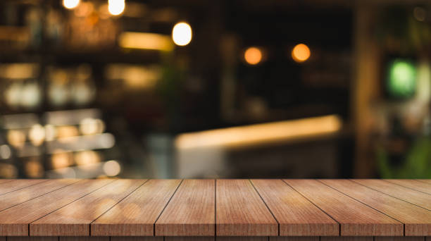 istock Empty wooden table top with lights bokeh on blur restaurant background. 1362722407