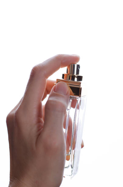 istock Perfume bottle in a female hand on a white background 1362724613