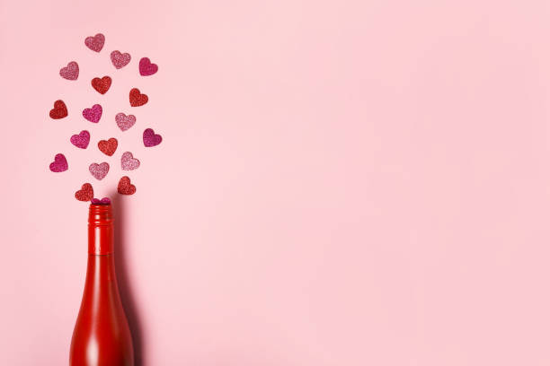 istock Romantic red bottle with hearts on pink background. Minimal Valentine's day card idea. Flat lay, top view 1362724780