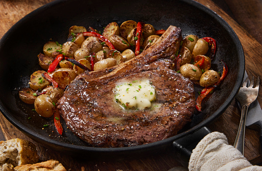 Pan Seared Rib Eye Steak with Roasted Potatoes, Red Peppers and a Garlic Herb Butter