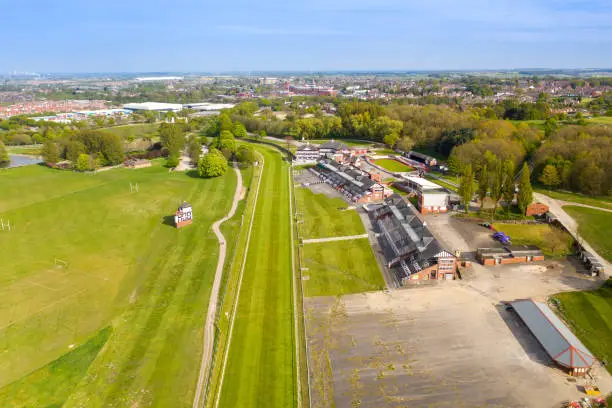 Aerial photo of the Pontefract race course located in the town of Pontefract in West Yorkshire in the UK, showing the main building and horse racing course, with the town of Castleford in the back