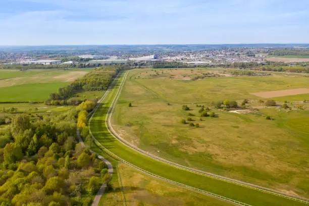 Aerial photo of the Pontefract race course located in the town of Pontefract in West Yorkshire in the UK, showing the main building and horse racing course, with the town of Castleford in the back