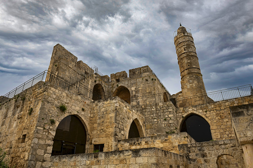 East Jerusalem, Palestine, May 5, 2019: Low angle view of the Tower of David - an ancient citadel located near the Jaffa Gate, the entrance to the Old City of Jerusalem, under cloudy sky.