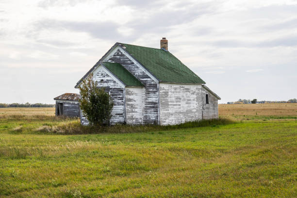 An old, abandoned house sitting in the middle of the great plains stock photo