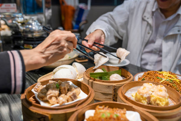 menschen essen guangdong dum sum mit essstäbchen im restaurant - eating men food chopsticks stock-fotos und bilder