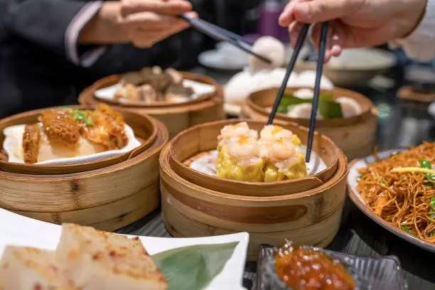 Photo of People eating Guangdong dum sum with chopsticks in the restaurant