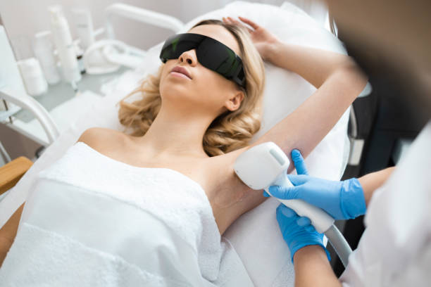 Beautyful blonde woman on underarm laser epilation procedure. Female doctor cosmetologist removes hair from the armpits of the patient Beautyful blonde woman on underarm laser epilation procedure. Female doctor cosmetologist removes hair from the armpits of the patient underarm stock pictures, royalty-free photos & images