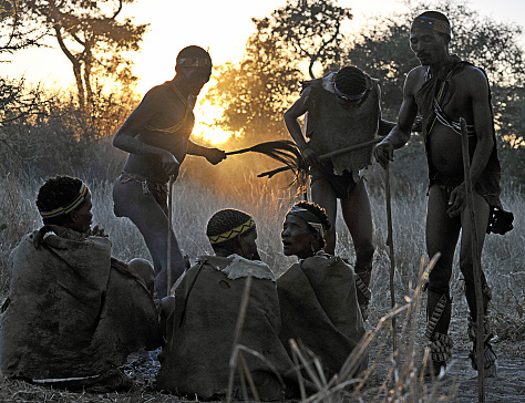 San bush people dance as the sun sets, Makgadikgadi Pans, Botswana, Southern Africa. The San are an ancient indigenous tribal people who inhabited much of southern Africa and although few in number today remain proud of their culture, ancestry and traditional ways of dress, customs and behaviour that included subsistence hunting and foraging