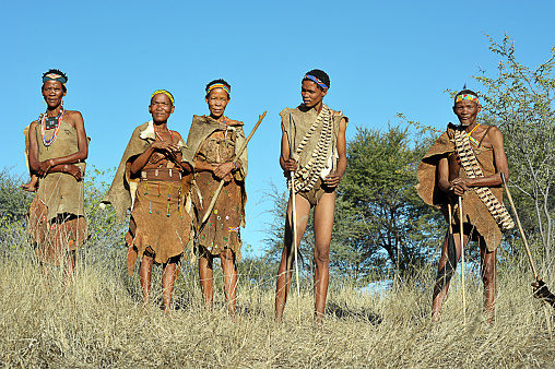 San bush people in line on hilltop, Makgadikgadi Pans, Botswana, Southern Africa. The San are an ancient indigenous tribal people who inhabited much of southern Africa and although few in number today remain proud of their culture, ancestry and traditional ways of dress, customs and behaviour that included subsistence hunting and foraging