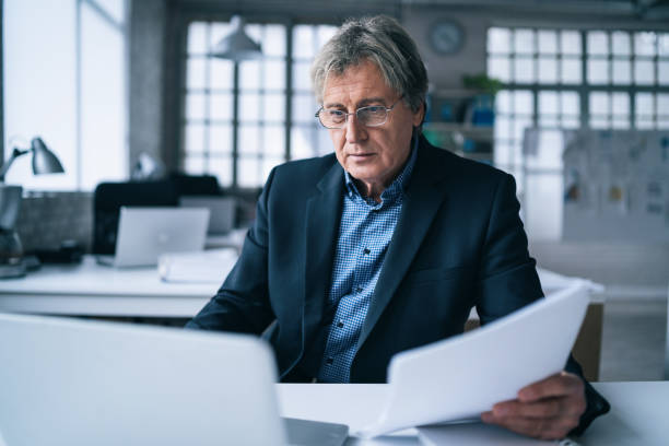 istock Senior businessman using laptop in the office 1362747826