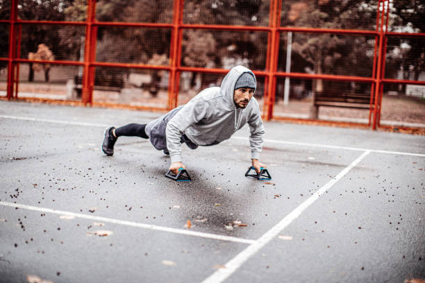 istock Young motivated man in his 20s practicing push-ups on a rainy day 1362748710