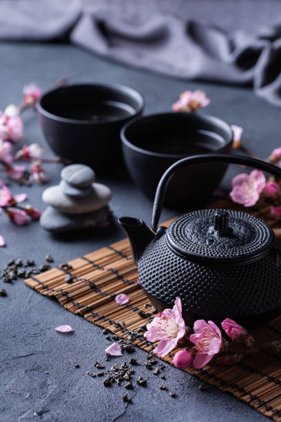istock Teapot and tea cups with blooming almond tree branches 1362749416
