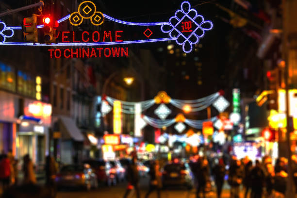 abstrakte verschwommene lichter einer geschäftigen new yorker straßenszene in chinatown bei nacht - stadtviertel chinatown stock-fotos und bilder