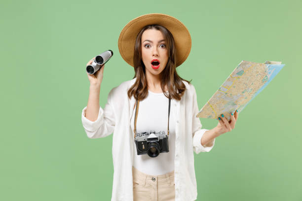 Traveler impressed exploring tourist woman in casual clothes hat hold paper map look through binoculars isolated on green background Passenger travel abroad weekends getaway Air flight journey concept viajero impresiona explorando turista mujer con ropa casual sombrero sostener mapa de papel mirar a través de binoculares aislados en fondo verde viaje de pasajeros al extranjero escapada fines de semana escapada vuelo aéreo concepto de viaje