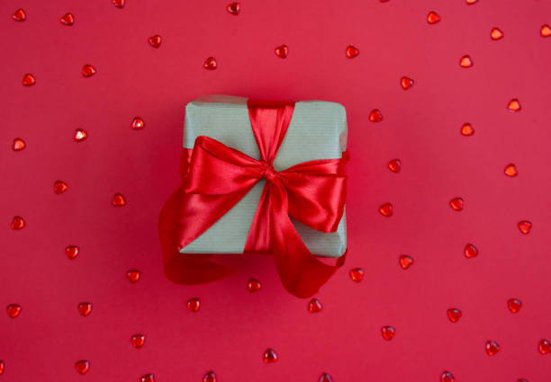 istock Gift box with red bow on red background. Festive background. Copy space. 1362758995