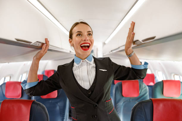 istock Joyful stewardess standing in airplane passenger salon 1362759313