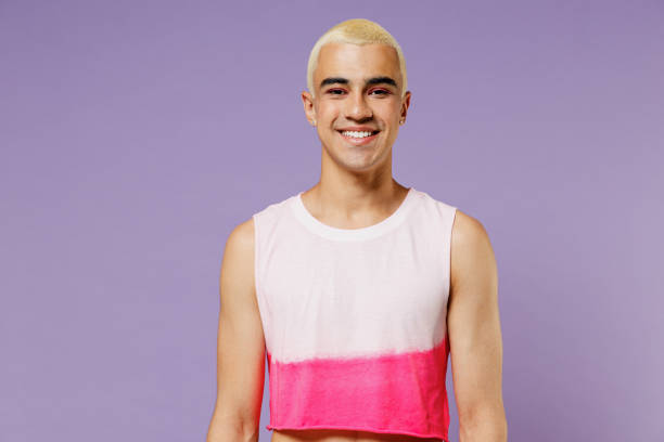 Young trendy blond hispanic latin gay man 20s with make up in fashionable bright pink top look camera isolated on plain pastel purple background studio portrait People lifestyle fashion lgbtq concept Young trendy blond hispanic latin gay man 20s with make up in fashionable bright pink top look camera isolated on plain pastel purple background studio portrait. People lifestyle fashion lgbtq concept gay man stock pictures, royalty-free photos & images