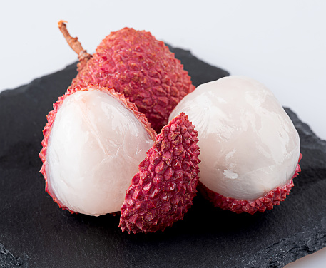 Lychee with leaves on white background. Tropical fruits
