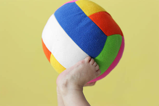 istock Child holds a ball by feet 136276381