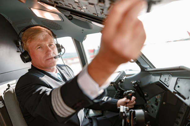 istock Man pilot in headphones controlling aircraft flight 1362766135
