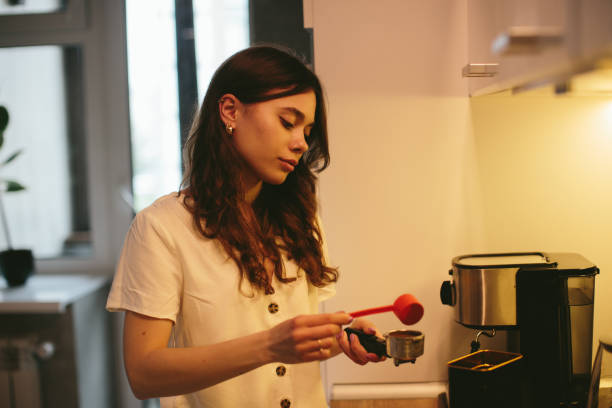 istock Young woman making morning coffee in the kitchen. 1362767508