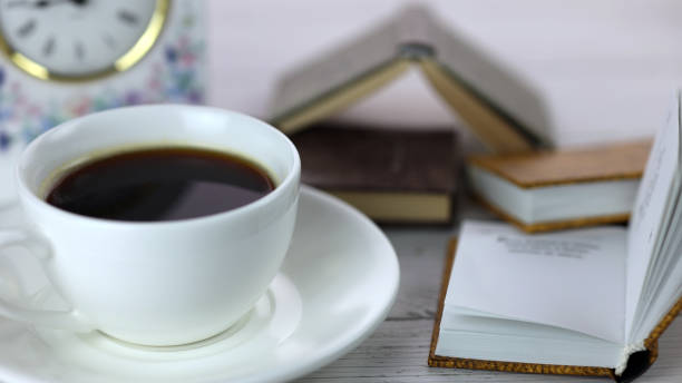 istock cup of coffee and books on the table, reading for breakfast 1362767990