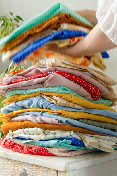 istock women's hands take a stack of clothes from the nightstand for laundry or recycling. children's or adult clothing from the wardrobe 1362768233