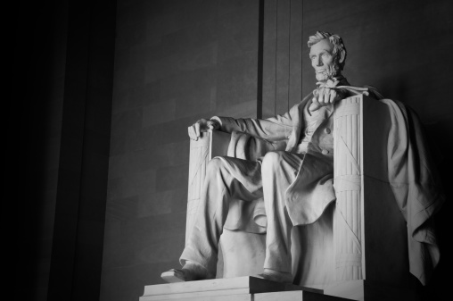 A monochrome image of the statue of Abraham Lincoln in the Lincoln in the Lincoln Memorial in Washington, DC.