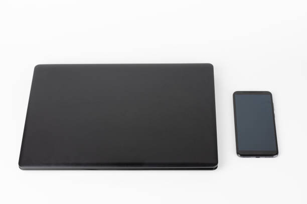 istock Modern, new office black laptop and touchscreen smarthphone in silicone case on white background 1362775715