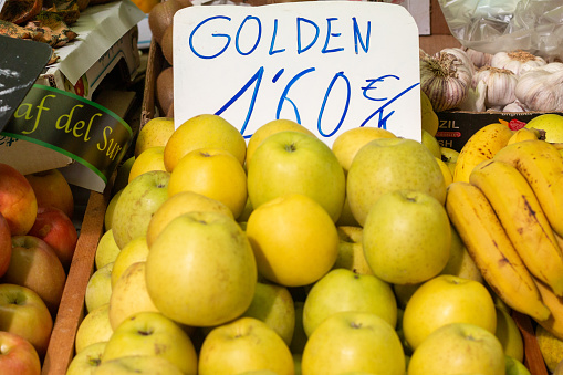 Golden Apple at Mercado Central (Central Market) in Valencia, Spain, with commercial logos in the background