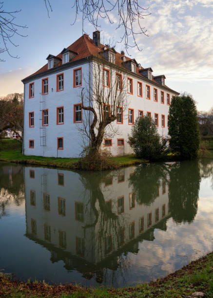 Lindlar, Germany - April 13, 2021: Castle Georghausen close to Lindlar with water reflection at evening hours on April 13, 2021 in Bergisches Land, Germany