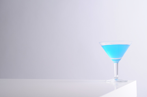 Blue martini glass on white table.