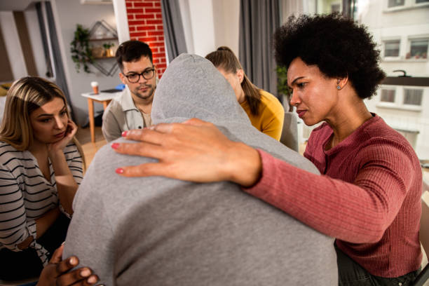 istock Diverse group of people sitting in circle in group therapy session. 1362787598