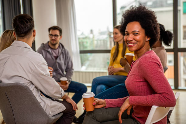 istock Diverse group of people sitting in circle in group therapy session. 1362787623