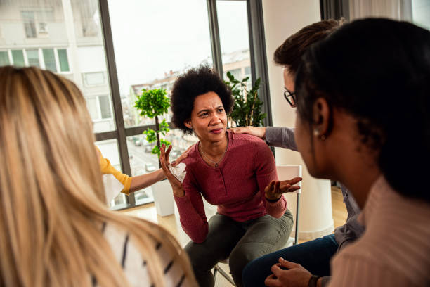 istock Diverse group of people sitting in circle in group therapy session. 1362787741