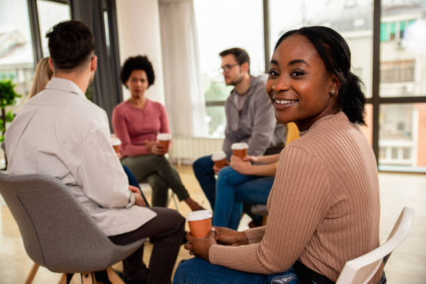istock Diverse group of people sitting in circle in group therapy session. 1362788025