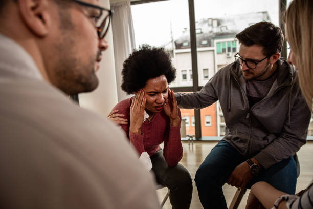 istock Diverse group of people sitting in circle in group therapy session. 1362788739