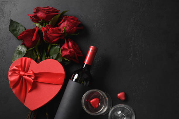 bouquet di rose rosse e regalo. biglietto di auguri di san valentino. - valentines present foto e immagini stock