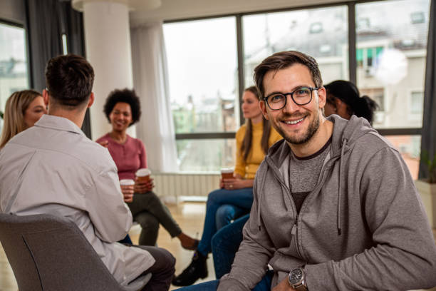 istock Diverse group of people sitting in circle in group therapy session. 1362789588