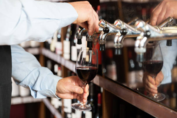 istock Bartender hand pouring draught red wine to glass 1362790878