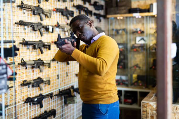 Man aiming while choosing gun in airsoft shop