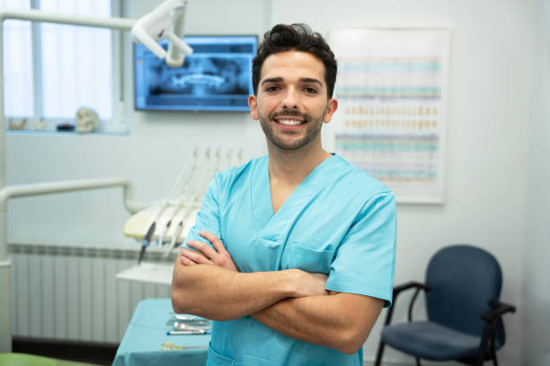 giovane dentista sorridente nella clinica dentale - igienista dentale foto e immagini stock