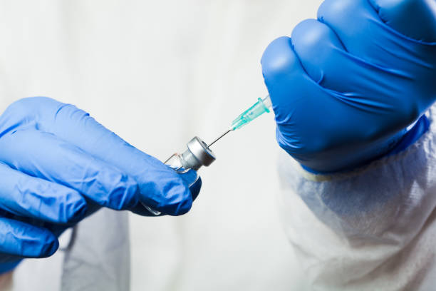 Closeup of syringe with needle in vaccine ampoule vial Closeup of medical worker hands in gloves holding syringe with needle drawing up vaccine shot dose,Coronavirus jab against new COVID-19 variant,protection and prevention of severe symptoms development anti inflammatory stock pictures, royalty-free photos & images