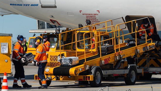 May 11, 2021, Moscow, Russia. Airport employees load baggage into the cargo hold of a passenger aircraft on the airfield of Sheremetyevo airport.