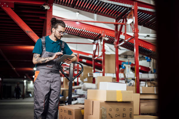 istock Young warehouse worker checking the boxes he put on the hand truck 1362807317