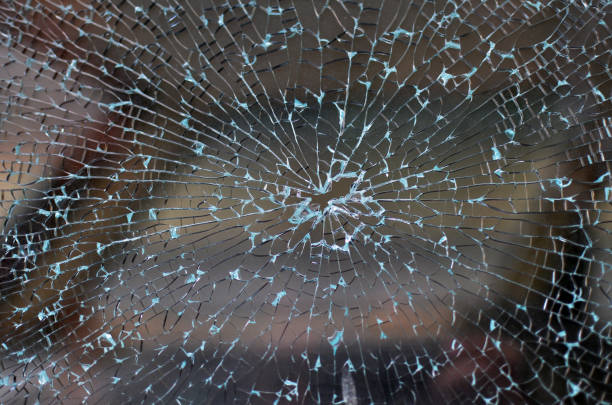 istock Broken car window with cracked glass pattern and a bullet hole in the middle 1362807591