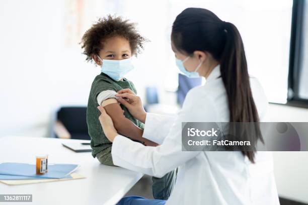 Getting A Bandage After A Vaccine Stock Photo - Download Image Now - Healthcare Worker, Smiling, Vaccination