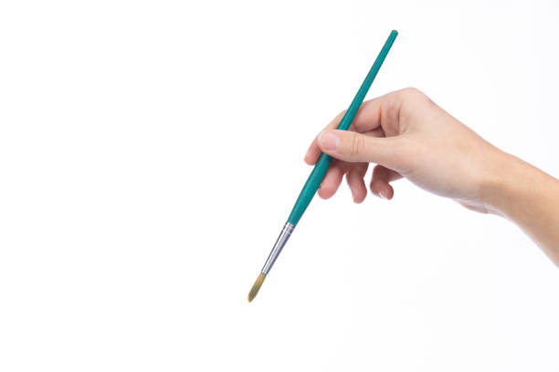 istock Art brush held in a lady's hand, on a white background 1362812112
