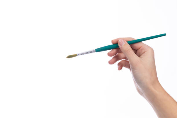 istock Art brush held in a lady's hand, on a white background 1362812115